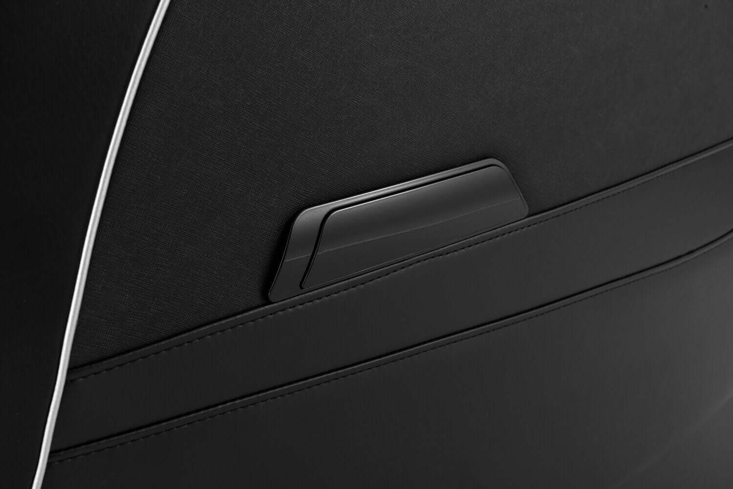 Close-up of the TRU Majestic massage chair's sleek black fabric and storage pocket design.